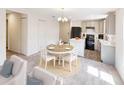 Dining area with a round table, white chairs, and an adjacent open kitchen at 2184 Hyatt Dr, Port Charlotte, FL 33948
