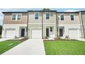 Three attached townhomes with white garages, and beige and green siding at 4280 Banjo Lake Rd, Land O Lakes, FL 34639