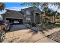 Inviting home with gray exterior, landscaped yard, and two-car garage at 11807 Holly Creek Dr, Riverview, FL 33569