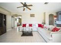 Open living room with white sectional sofa, coffee table, ceiling fan, and tile floors at 11807 Holly Creek Dr, Riverview, FL 33569