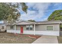 Newly renovated one-story house featuring gray exterior and red front door at 11615 Meadow Dr, Port Richey, FL 34668