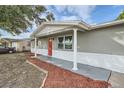 Newly remodeled home with gray exterior and red front door at 11615 Meadow Dr, Port Richey, FL 34668