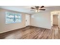 Bright living room with wood-look floors and ceiling fan at 11615 Meadow Dr, Port Richey, FL 34668