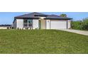 One-story house with attached garage and large lawn at 1649 N San Mateo Dr, North Port, FL 34288