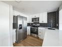 Modern kitchen with white cabinets and stainless steel appliances at 1490 Fundy Rd, Venice, FL 34293
