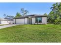 Charming single-story home with a lush green lawn and a convenient two-car garage at 4495 Eldron Ave, North Port, FL 34286