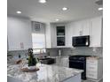 Modern kitchen featuring white cabinets, marble countertops, and stainless steel appliances at 5519 Turtle Crossing Loop, Tampa, FL 33625