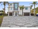 Modern home exterior with two-car garage and paver driveway at 7801 9Th S Ave, St Petersburg, FL 33707