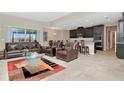 Open living room with leather furniture, and kitchen view at 33161 Kateland Dr, Wesley Chapel, FL 33545