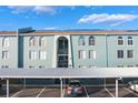 Light teal building with parking and landscaping at 275 114Th N Ave # 2, St Petersburg, FL 33716