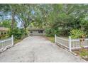 Front view of a house with a long driveway and white picket fence at 4135 Bell Ave, Sarasota, FL 34231