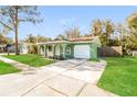 Front view of a light green house with a grassy yard at 4545 Weasel Dr, New Port Richey, FL 34653