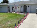 Landscaped yard with American flags lining the driveway at 302 Strasburg Dr, Port Charlotte, FL 33954