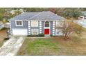 Two-story house, gray siding, red door, and driveway at 7319 Lagoon Rd, Spring Hill, FL 34606