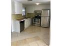 Galley kitchen with white cabinets and stainless steel appliances at 7539 Marechal Ave, Port Richey, FL 34668