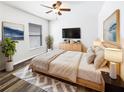Relaxing bedroom with a ceiling fan, large window, and wood-look flooring at 34434 Windknob Ct, Wesley Chapel, FL 33545