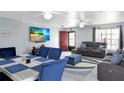 Stylish living room featuring a sofa, dining area, and a bright red door at 15427 Winter Breeze Ln, Wimauma, FL 33598