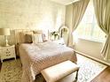 Charming bedroom featuring a queen bed, decorative mirror, and soft color scheme at 6302 Rosefinch Ct # 104, Lakewood Ranch, FL 34202
