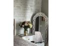 Close-up of a bedroom with a decorative mirror and a vase of flowers at 6302 Rosefinch Ct # 104, Lakewood Ranch, FL 34202