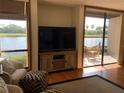 Bright living room featuring a waterfront view through large windows and sliding glass doors to a patio at 1322 Pelican Creek Xing # B, St Petersburg, FL 33707