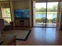 Bright living room features a waterfront view through large windows and sliding glass doors to a patio at 1322 Pelican Creek Xing # B, St Petersburg, FL 33707