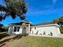Side view of the home with well maintained lawn and attractive landscaping, showcasing its architectural design at 37 Warrington Blvd, Port Charlotte, FL 33954