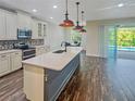 Open kitchen with pendant lights, island sink, and view of screened pool at 7480 Aguila Dr, Sarasota, FL 34240