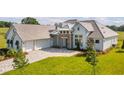 Attractive exterior view with a three car garage, manicured lawn, and stone facade at 14036 Prairie Hill Rd, Dade City, FL 33525