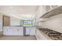 Modern kitchen featuring white cabinetry, stainless steel appliances, granite countertops, and view of the backyard at 14370 Hammock Oak St, Parrish, FL 34219