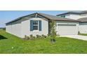 Lovely single-story home with a two-car garage and landscaped front yard under a sunny sky at 31629 Malbec Dr, Brooksville, FL 34602