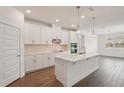 Bright, modern kitchen features white cabinets, stainless steel appliances and wood-look tile flooring at 466 Sun Chaser Dr, Nokomis, FL 34275