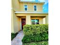 Cozy front porch with a welcoming sign, a red door, green shrubbery, and a brick walkway at 109 Tierra Verde Way, Bradenton, FL 34212