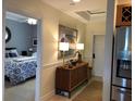 Hallway view with a glimpse into the bedroom, showcasing tiled floors, decorative lighting, and a glimpse into the kitchen at 3233 Purple Martin Dr # 121, Punta Gorda, FL 33950