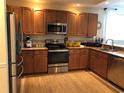 Functional kitchen featuring stainless steel appliances, warm wood cabinets, granite countertops, and tiled backsplash at 3233 Purple Martin Dr # 121, Punta Gorda, FL 33950