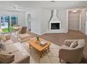 Bright living room boasts a fireplace and stylish furniture, opening to a dining area with sliding glass doors at 2956 Laurel Ct, Dunedin, FL 34698