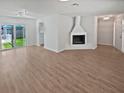 Spacious living room with wood-look floors and a fireplace, offering plenty of natural light at 2956 Laurel Ct, Dunedin, FL 34698