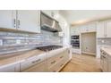 Modern kitchen features grey subway tile backsplash, stainless steel appliances, and ample cabinet space at 14451 Coastal Woodland Ln, Parrish, FL 34219