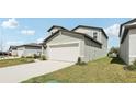Light gray home showcasing a two-car garage and a manicured lawn at 2318 E Newsome Rd, Plant City, FL 33565