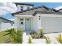 Close up of a charming home with a blue front door, two-car garage and manicured landscaping at 3912 Radiant Mountain Dr, Plant City, FL 33565