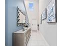 Bright foyer with high ceilings, stylish mirror, console table, and contemporary artwork at 13327 Willow Bluestar Loop, Riverview, FL 33579