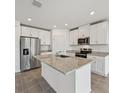 Bright kitchen features stainless steel appliances, white cabinets, and a granite island at 225 Lazy Shore Dr, Nokomis, FL 34275