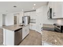 Bright kitchen features stainless steel appliances, white cabinets, and a granite island at 225 Lazy Shore Dr, Nokomis, FL 34275