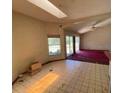 Bright living room with tile flooring, large windows, and a ceiling fan offering plenty of natural light at 18316 Oxenham Ave, Spring Hill, FL 34610