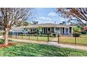 Inviting single-story home showcasing a lush front yard, enhanced by a decorative fence and mature trees at 105 17Th Ne Ave, St Petersburg, FL 33704