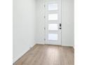 Bright entryway featuring wood-look tile flooring and a modern front door with frosted windows at 1832 Draughton Dr, Zephyrhills, FL 33541