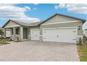 Lovely one-story home with three-car garage and appealing brick driveway and front yard landscaping at 1832 Draughton Dr, Zephyrhills, FL 33541