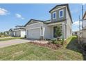 A charming, light gray two-story home featuring a well-manicured front yard and a two-car garage at 1852 Brekey Way, Zephyrhills, FL 33541