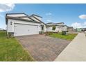 Lovely single-Gathering home with a two-car garage, brick driveway, and a well-manicured front lawn at 1868 Brekey Way, Zephyrhills, FL 33541