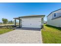 New home featuring a two-car garage and paved driveway, landscaping and lush lawn at 1876 Brekey Way, Zephyrhills, FL 33541