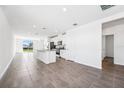 Open-plan living space with tile floors, modern fixtures, and a kitchen with granite countertops at 1876 Brekey Way, Zephyrhills, FL 33541